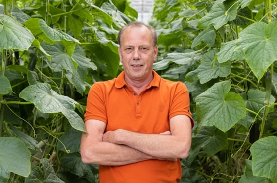 Frank Schoenmakers in greenhouse in between plants