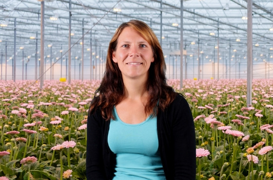 Picture of Caroline Polzin in greenhouse in between plants