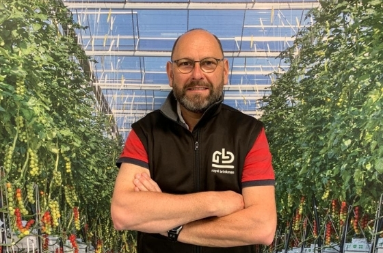 Picture of Eric le Moal in greenhouse in between plants